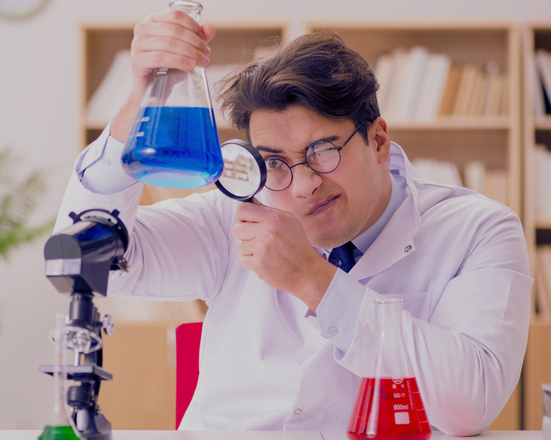 Male scientist closely examining a blue liquid in a lab beaker, symbolizing the science behind busting lube and friction myths for Happy Lube's blog.